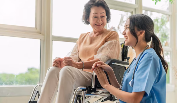 asian-young-caregiver-caring-her-elderly-patient-senior-daycare-handicap-patient-wheelchair-hospital-talking-friendly-nurse-looking-cheerful-nurse-wheeling-senior-patient_609648-3125